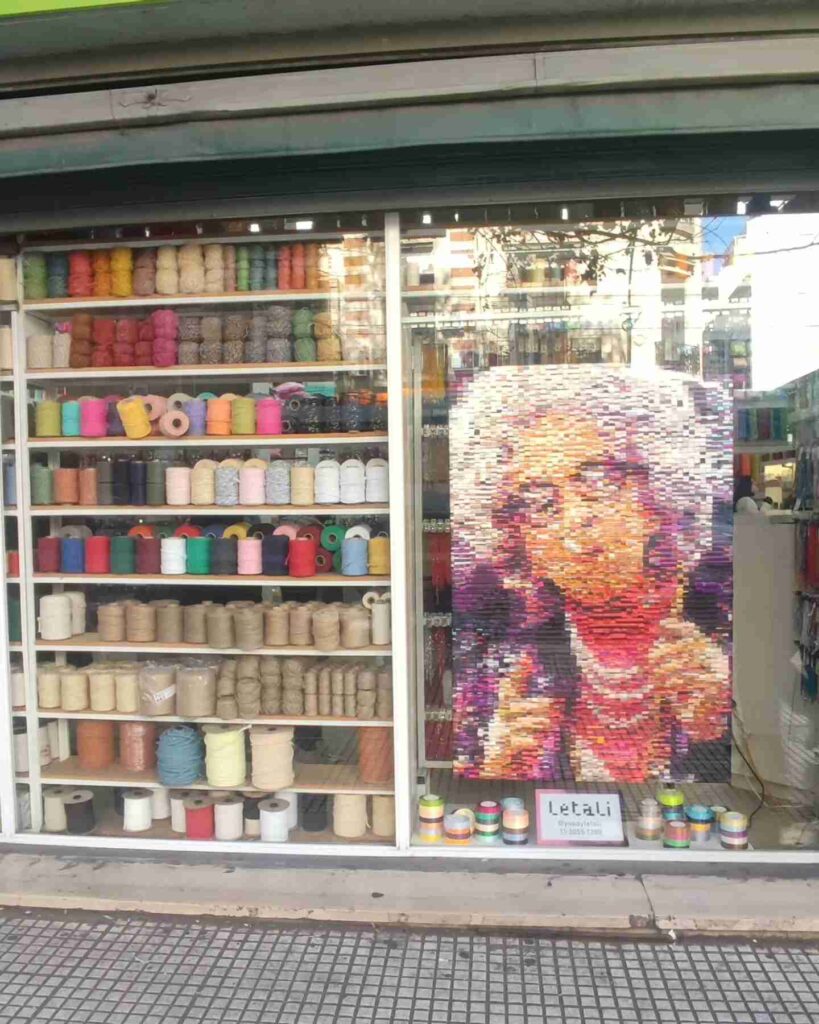 Once: la artista Letali realizó un cuadro con cintas de razo sobre la abuela Yetta en la vidriera del Almacén de Armado